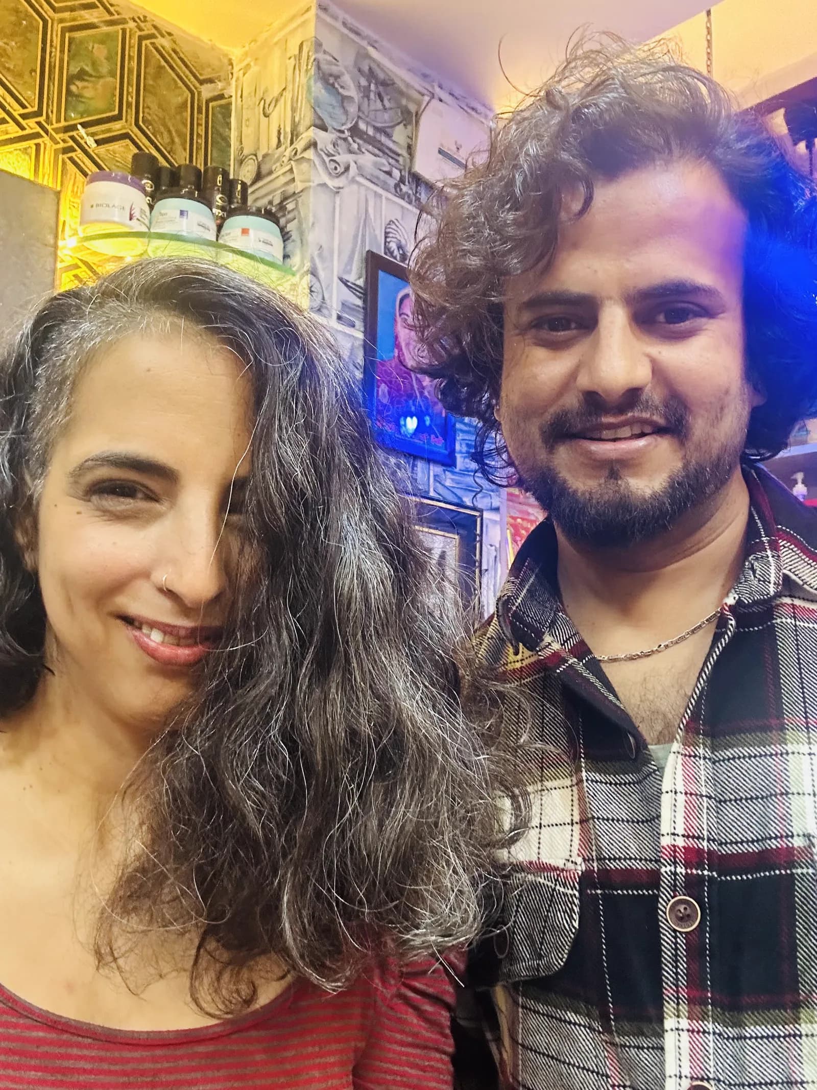 A client showing her finished hairstyle with her stylist